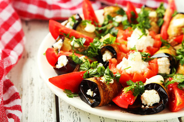 Tasty eggplant rolls on white wooden background
