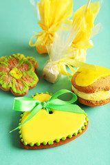 Heart shaped cookies with candies on green background
