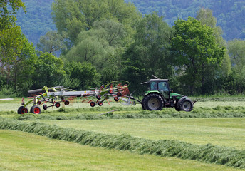 Traktor beim Heuwenden