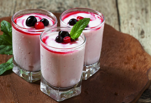 Homemade yogurt with berry juice and currants in a glass, select