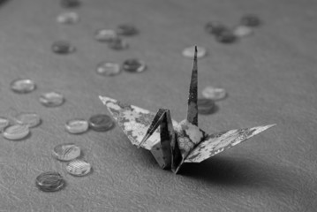 折り紙を折った鶴とおはじきをモノクロで撮影しました.
