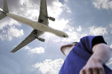 A man looks a airplane passing above him