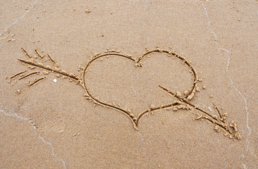 heart with an arrow on sand