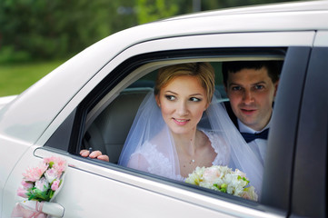 Portrait of bride and groom in limousine