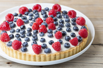 Cake with blueberries and raspberries. Confectionery product.