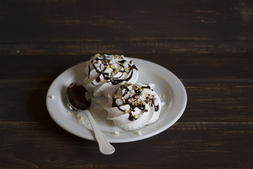 Meringue with chocolate sauce and nuts