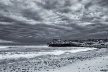 Fototapeta premium Black and white landscape of ocean rocks and clouds artistic con