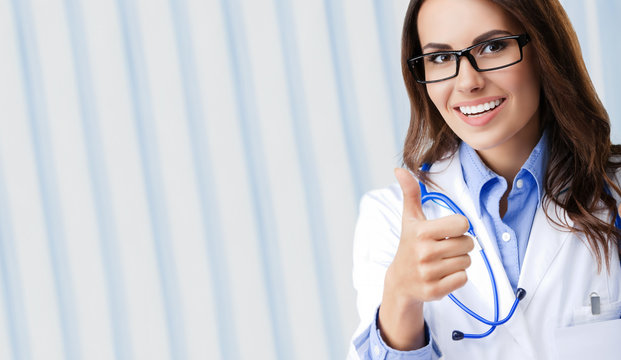 Young doctor showing thumbs up gesture, with copyspace