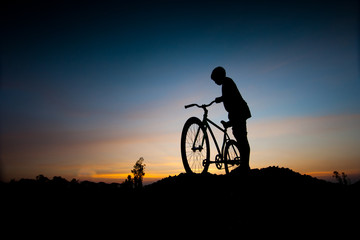 silhouette of children and bicycle at sunset