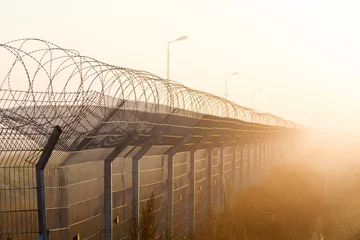 Rolgordijnen fence with barbed wire on the border © miklyxa