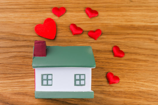 house with red heart on wooden background