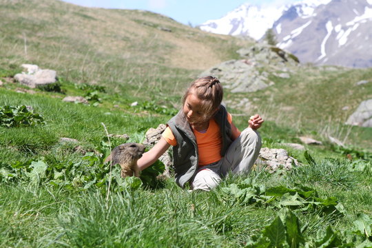 mère et fille donnant à manger à une marmotte