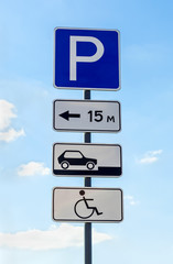 Close-up of a handicapped parking sign against blue sky
