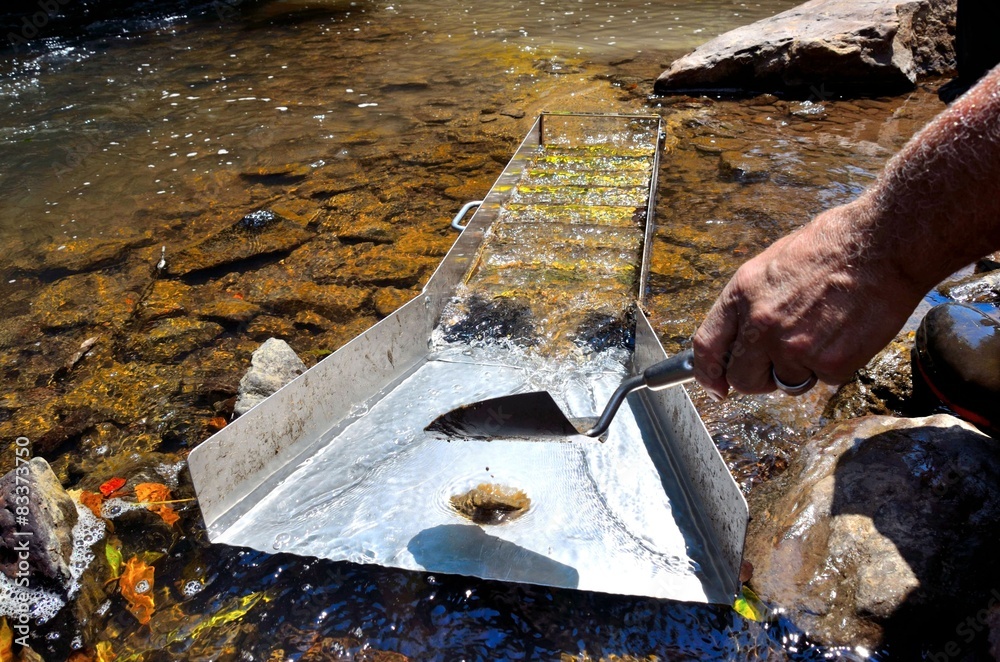 Wall mural Gold panning with a sluice box in a river