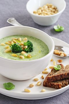 Broccoli-potato soup with pine nuts and broccoli topping 