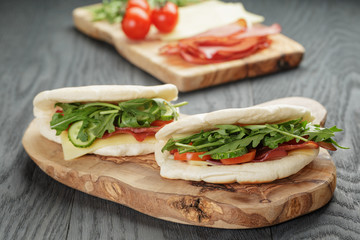 rustic sandwiches with ham arugula and tomatoes in pita bread