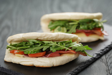 rustic sandwiches with ham arugula and tomatoes in pita bread