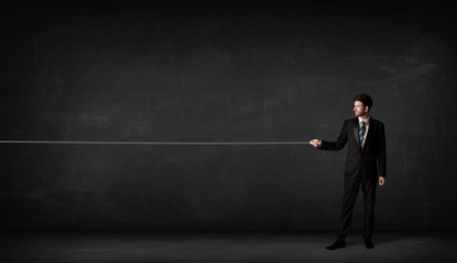 Obraz premium Businessman pulling rope on grey background