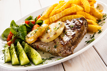 Grilled steak, French fries and vegetables