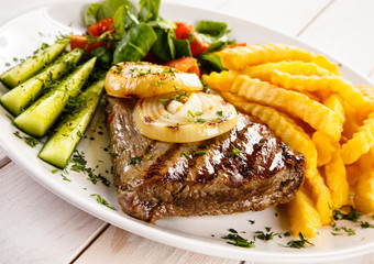 Grilled steak, French fries and vegetables