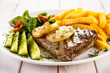 Grilled steak, French fries and vegetables