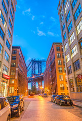 The Manhattan Bridge framed at night by Brooklyn buildings