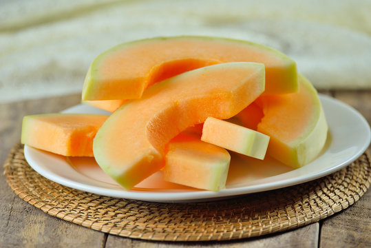 cantaloupe melon slices  on white plate