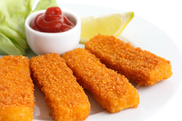 Golden fried fish fingers with lemon and tomato sauce.