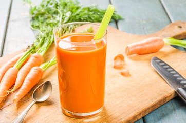 Ein Glas Karottensaft mit frischen Möhren
