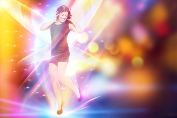 Woman with headphones is dancing over colorful background