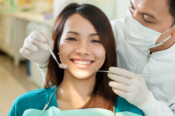 Portrait of smiling asian woman sitting at the dentist - 83391397