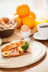 Delicious ham and cheese croissant on a wooden table