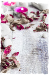 Obraz na płótnie Canvas Stones candles petals rose wooden background