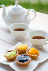 Fruit tart with tea on wooden board, afternoon tea