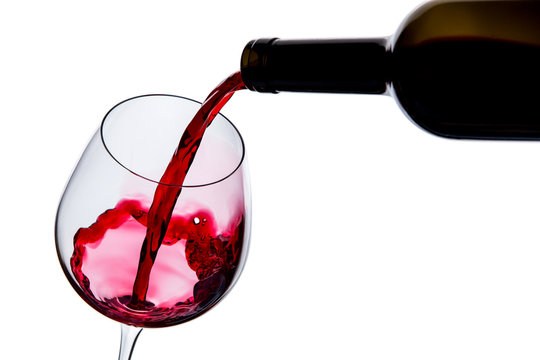 red wine poured into a glass on a white background