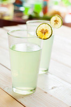 Cold lemonade in a glass, served with a slice of a lemon