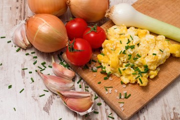 One portion of scrambled eggs and various vegetable