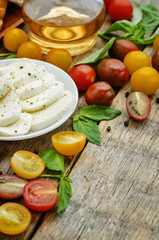 wood background with tomatoes, Basil, mozzarella, bread