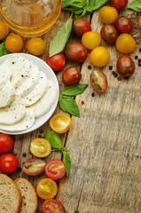 wood background with tomatoes, Basil, mozzarella, bread