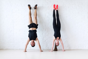 sportsmen woman and man doing a handstand against wall concept