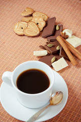 Cup of coffee with cookies, chocolate and spices on a table. Sel