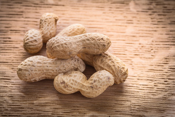little stack of peanuts on wooden board food and drink concept