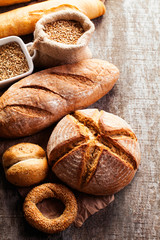 Assortment of baked bread on wooden table background