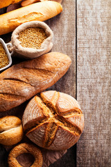 Assortment of baked bread on wooden table background