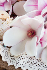 magnolia flowers with pearls on wooden table