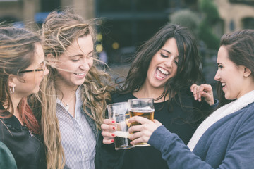 Group of women enjoying a beer at pub in London.