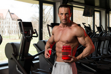 Bodybuilder Posing With Supplements For Copy Space