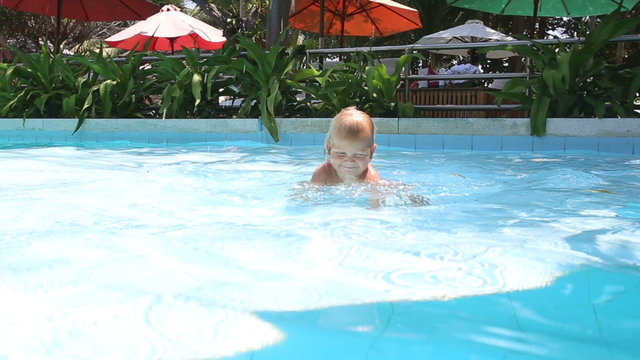 blonde little girl flops into swimming pool	