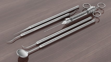 Set of stainless dental instruments on wooden background
