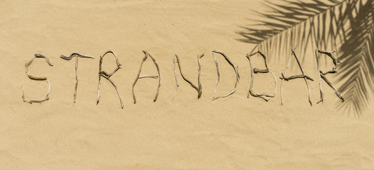 Strandbar aus Treibholz im Sand geschrieben